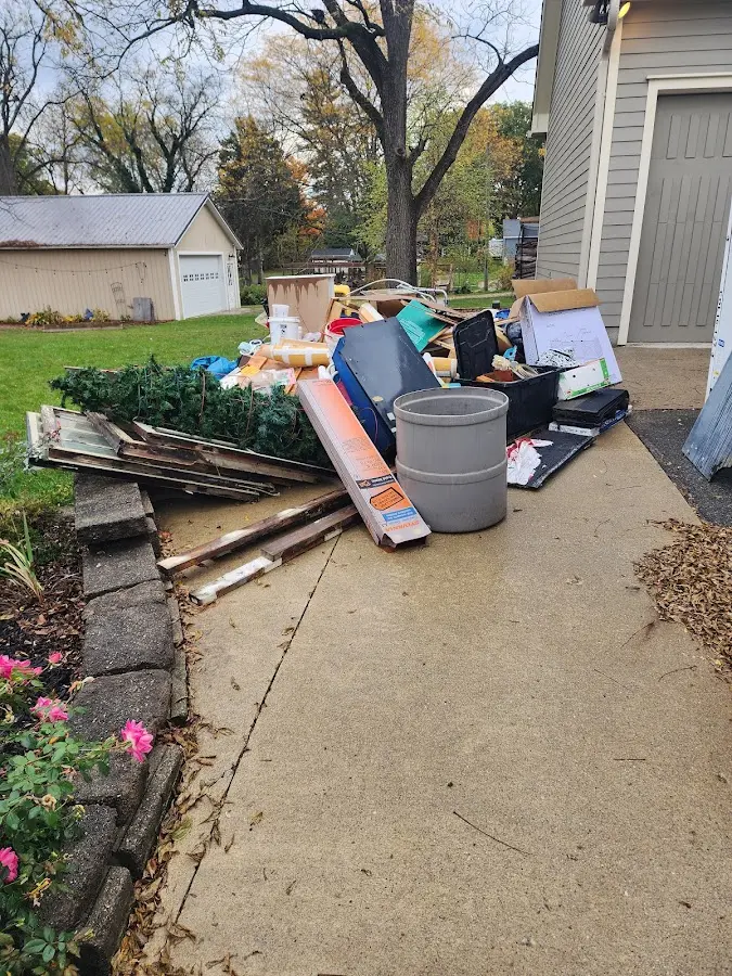 Dumpster being loaded with debris for 12 Yard Dumpster Rental in Leo-Cedarville